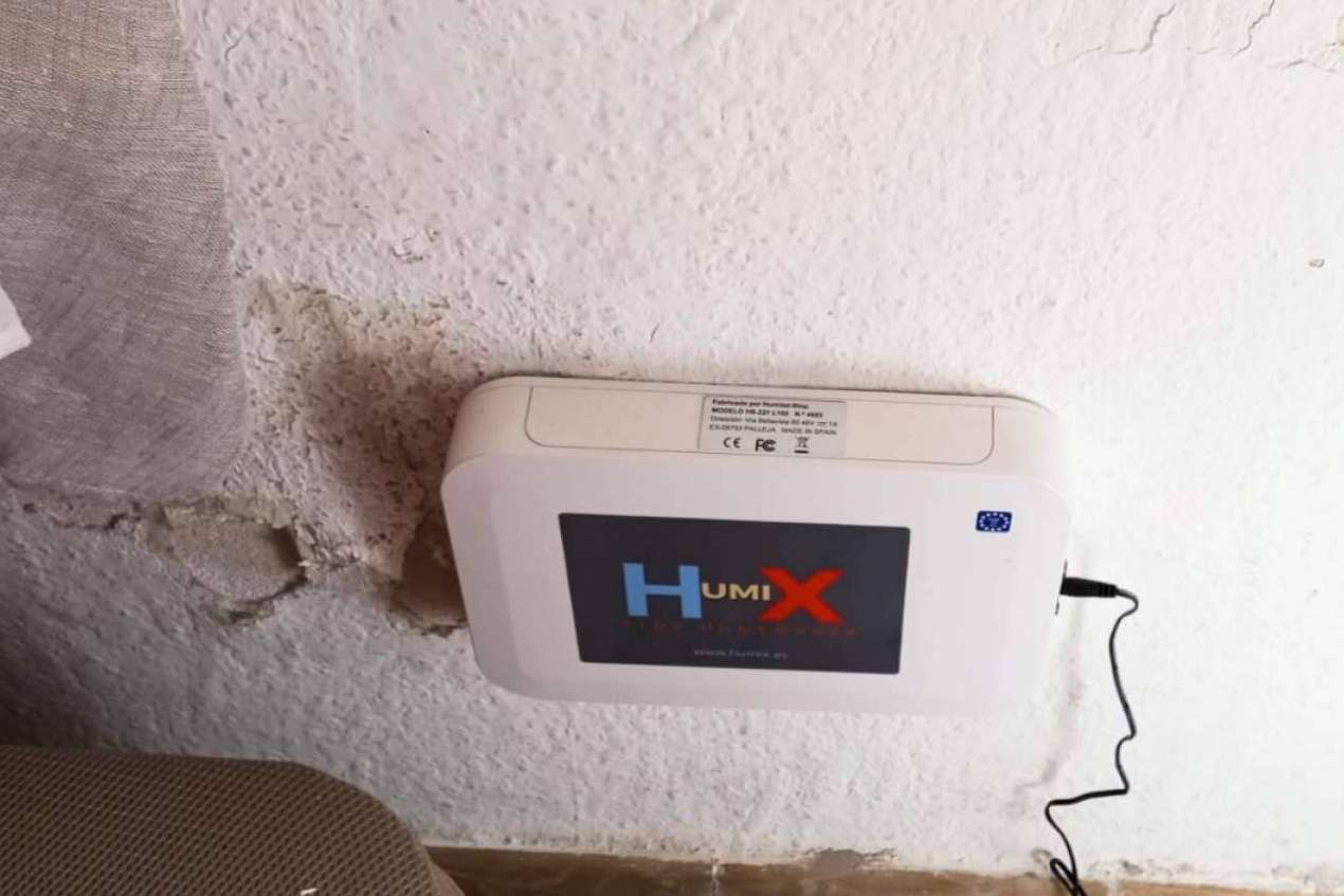 Equipo HUMIX HS-221 instalado en muro con signos de humedad